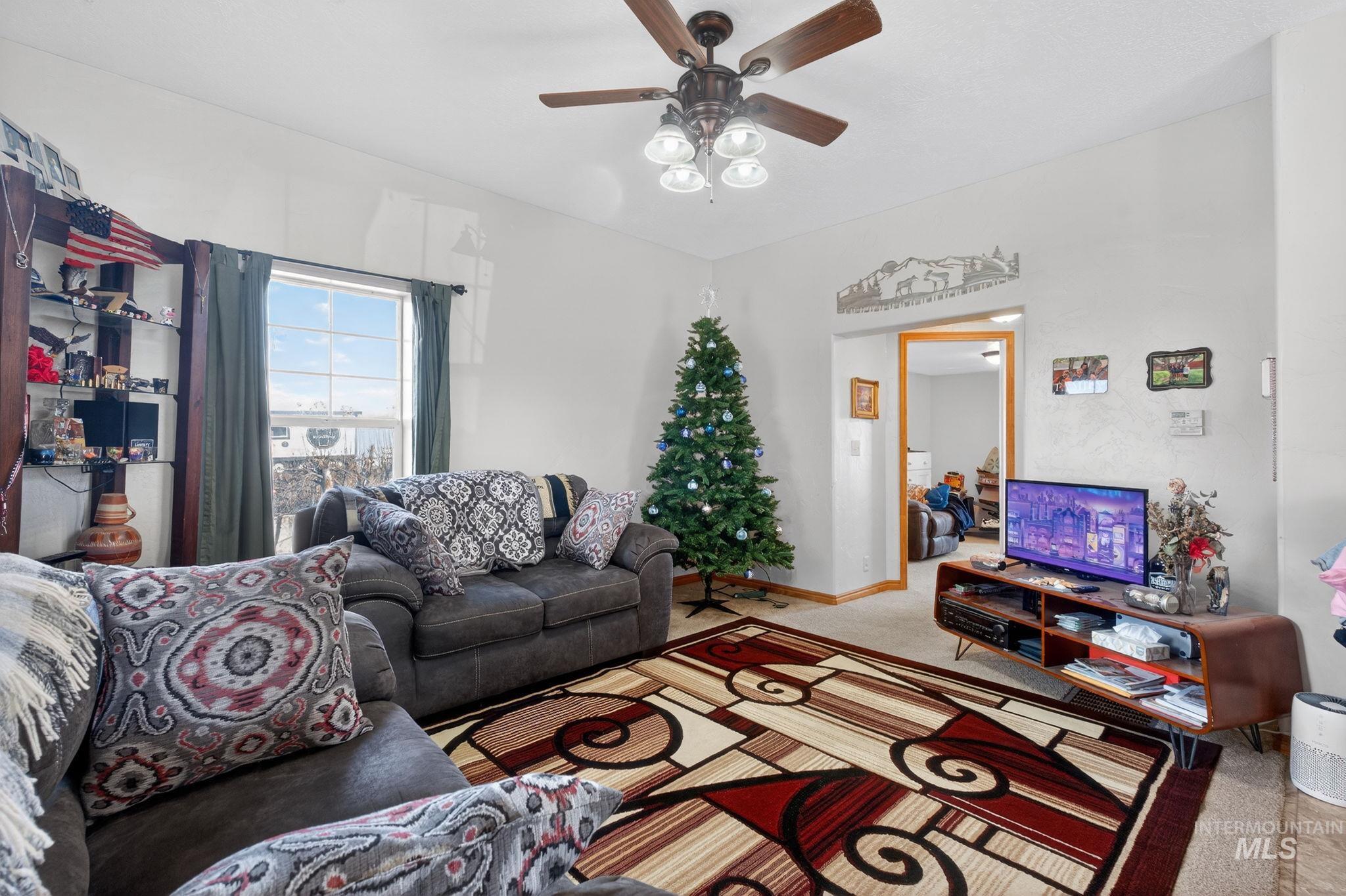 49 South 4th Street West Preston, ID 83263 - Photo 2 of 48 Carpeted living room featuring baseboards and ceiling fan