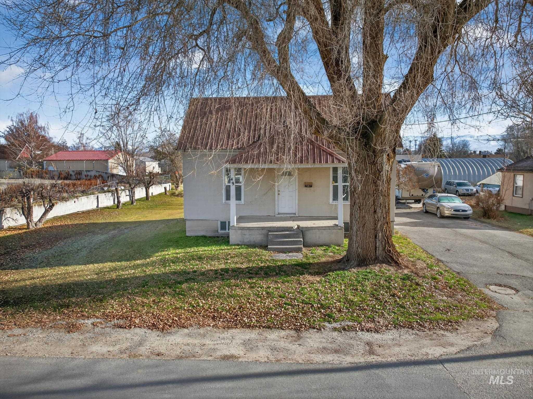 49 South 4th Street West Preston, ID 83263 - Photo 33 of 48 View of front of home with a porch, a front lawn, asphalt driveway, and a metal roof