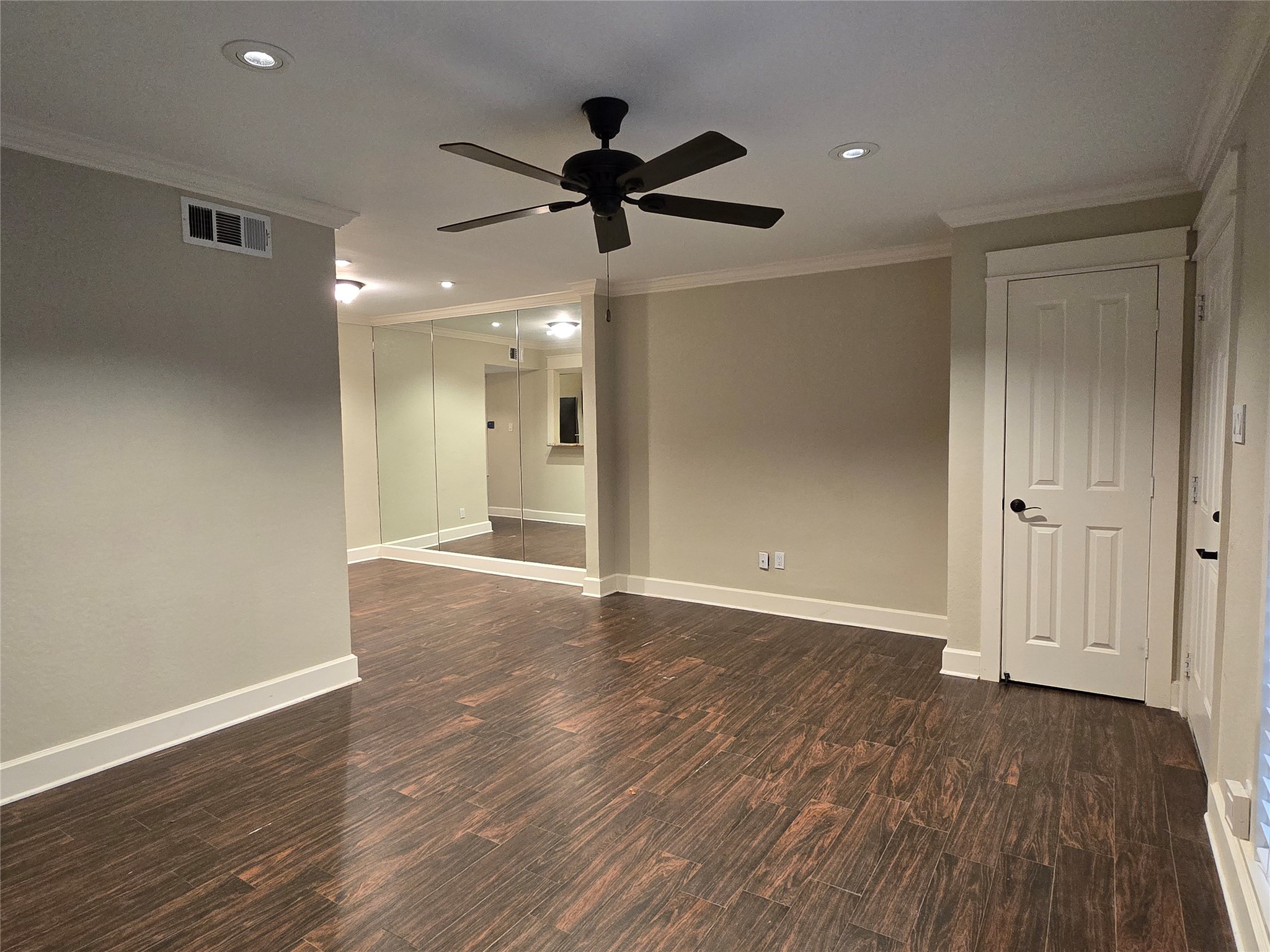 11550 Chimney Rock Road, Unit 312 Houston, TX 77035 - Photo 5 of 18 a view of an empty room with wooden floor and a ceiling fan