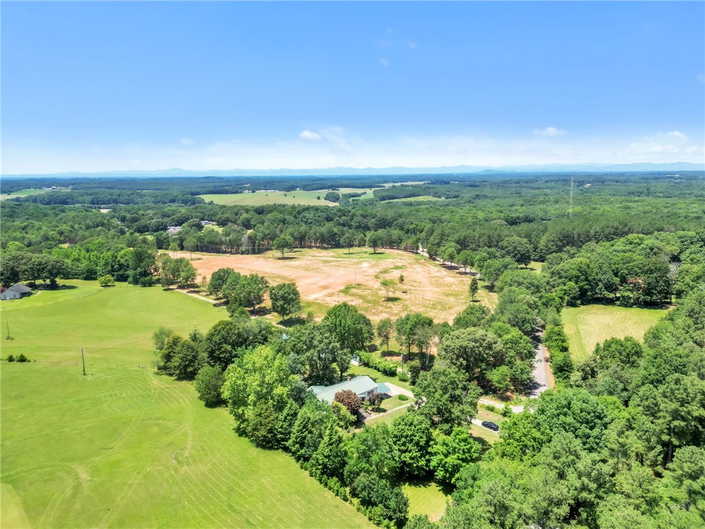 602 Harper Road Pendleton, SC 29670 - Photo 29 of 32 An aerial panorama reveals a vast rural landscape with wooded areas and open fields surrounding a secluded residence.