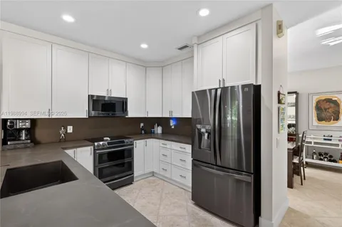 a kitchen with stainless steel appliances granite countertop a refrigerator stove and microwave