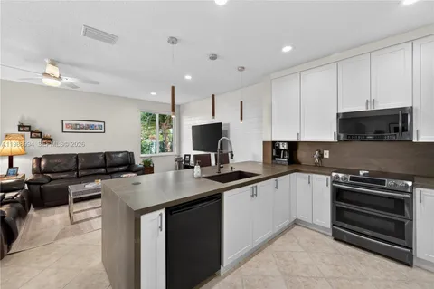 a kitchen with stainless steel appliances a stove sink microwave and cabinets