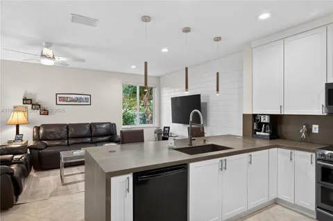 a kitchen with a sink dishwasher a stove a microwave a refrigerator and cabinets