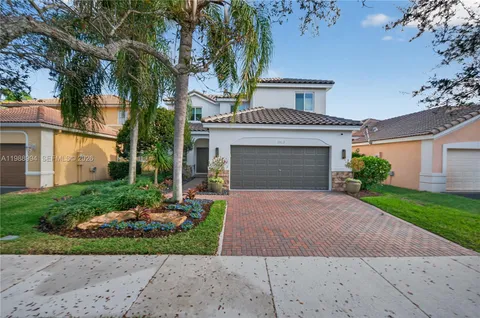 a front view of a house with a garden and plants