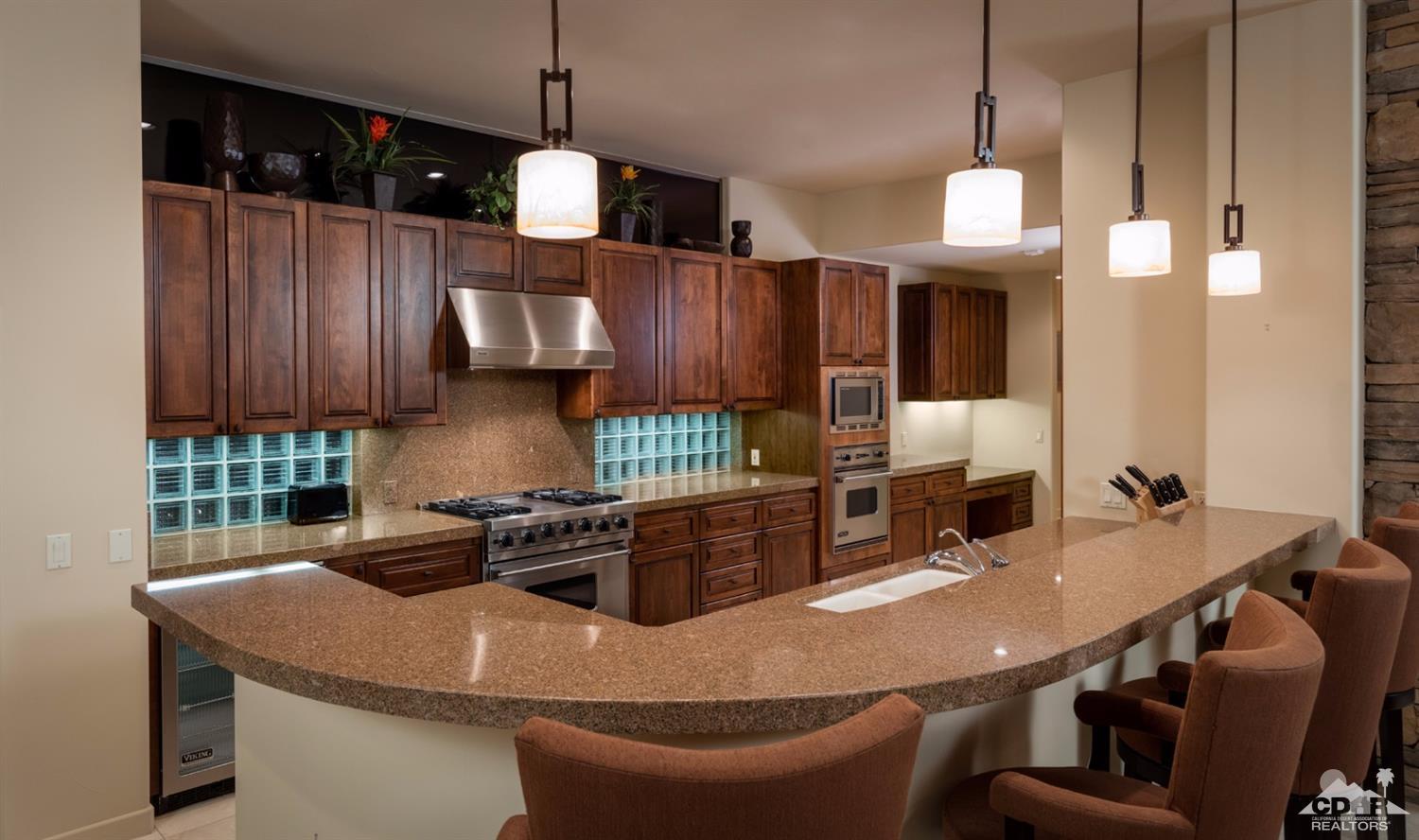 810 Shadow Vista Palm Desert, CA 92260 - Photo 6 of 11 a kitchen with stainless steel appliances granite countertop a sink a stove and a wooden cabinets