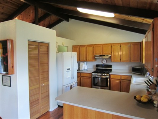 18-3976 Canney Road Mountain View, HI 96771 - Photo 8 of 25 a kitchen with stainless steel appliances a stove a refrigerator and cabinets