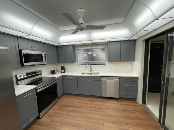 a large kitchen with cabinets wooden floor and stainless steel appliances