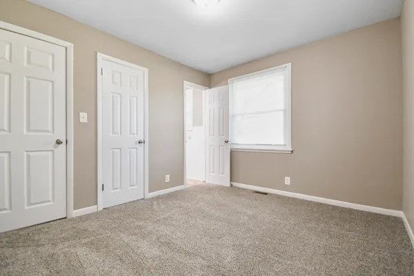an empty room with windows and closet