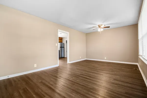 a view of an empty room with wooden floor