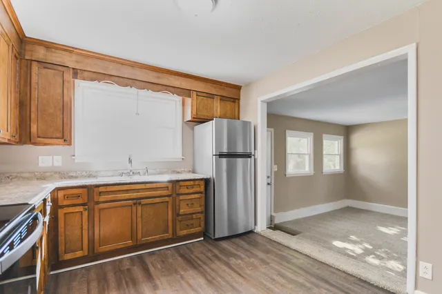 a view of a kitchen with a sink and dishwasher refrigerator freezer