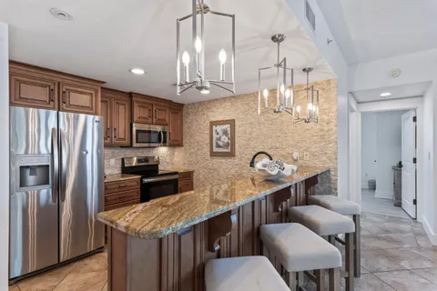 a living room with furniture two window and a chandelier