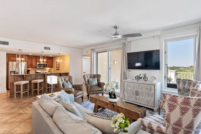 a living room with furniture a flat screen tv and a floor to ceiling window