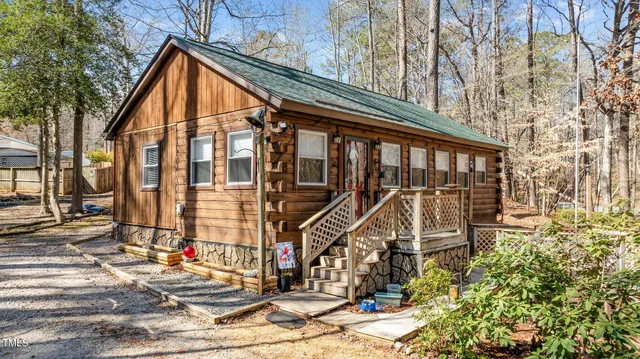 a view of wooden house with large windows and wooden fence