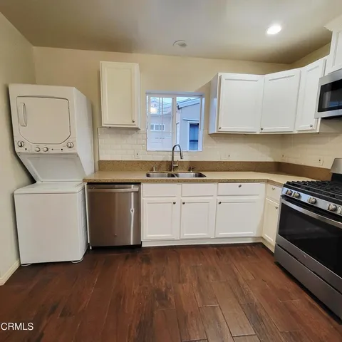 a kitchen with a sink a stove and cabinets