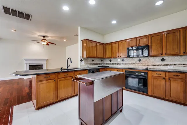 a kitchen with stainless steel appliances granite countertop a sink stove and cabinets