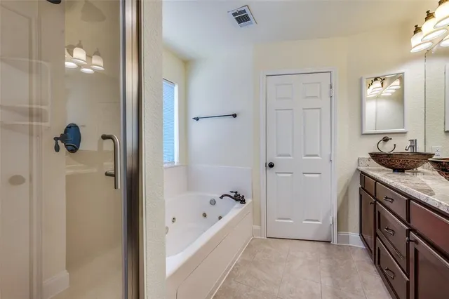 a bathroom with a granite countertop sink a mirror and a bathtub