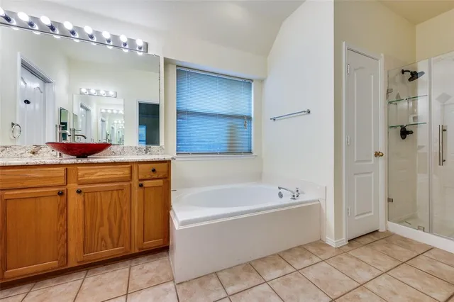 a bathroom with a tub a double vanity sink and a mirror