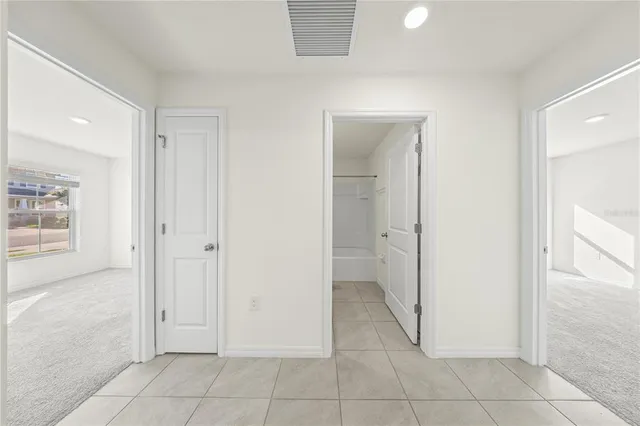 a view of a hallway with closet and a bathroom