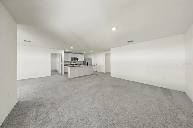 a view of a kitchen with sink refrigerator and wooden floor