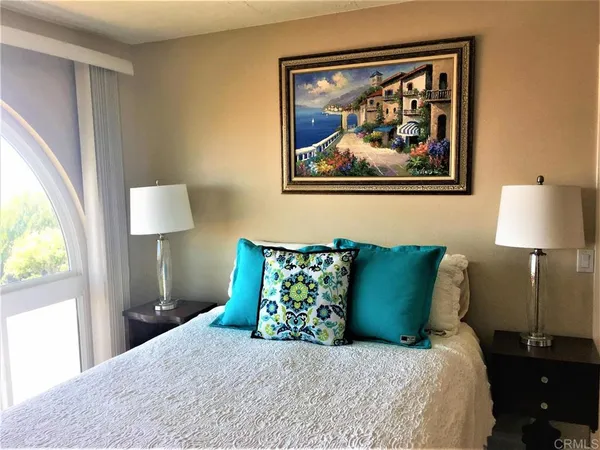 a bedroom with a bed and painting on the wall