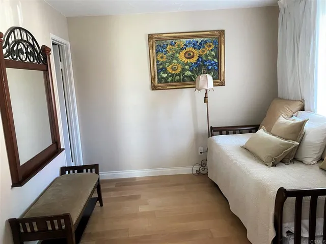 a bedroom with a bed and a painting on the wall