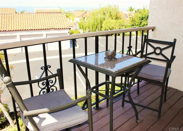 a view of a balcony with wooden floor and seating space