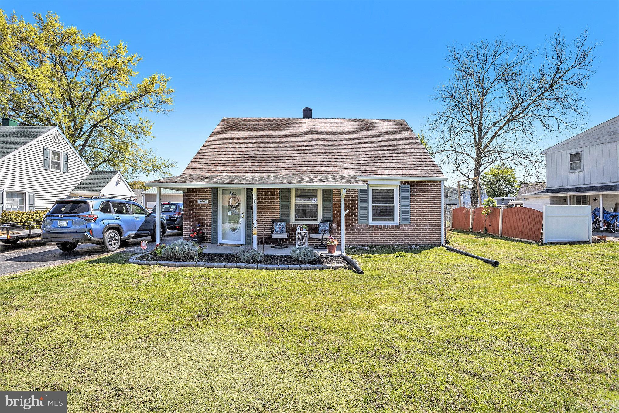 a front view of a house with a garden and trees