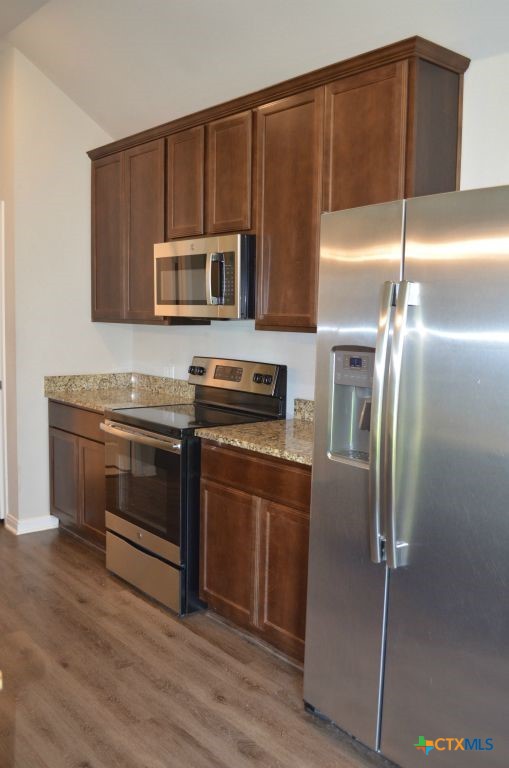 3414 Addison Street Killeen, TX 76542 - Photo 11 of 36 a kitchen with granite countertop a refrigerator and a stove top oven