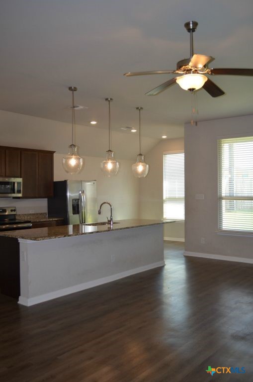 3414 Addison Street Killeen, TX 76542 - Photo 12 of 36 a view of a kitchen with a stove wooden floor and a chandelier