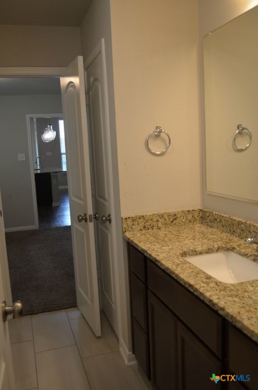 3414 Addison Street Killeen, TX 76542 - Photo 20 of 36 a bathroom with a granite countertop sink and a mirror