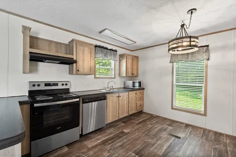 a kitchen with granite countertop a stove a sink and a microwave