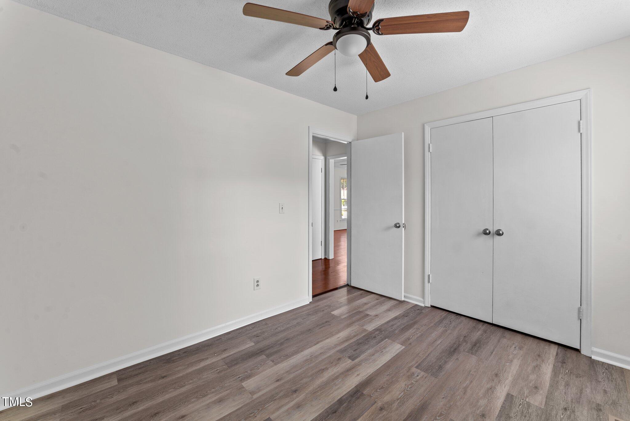 207 Freestone Road Greenville, NC 27834 - Photo 31 of 45 an empty room with wooden floor ceiling fan and windows