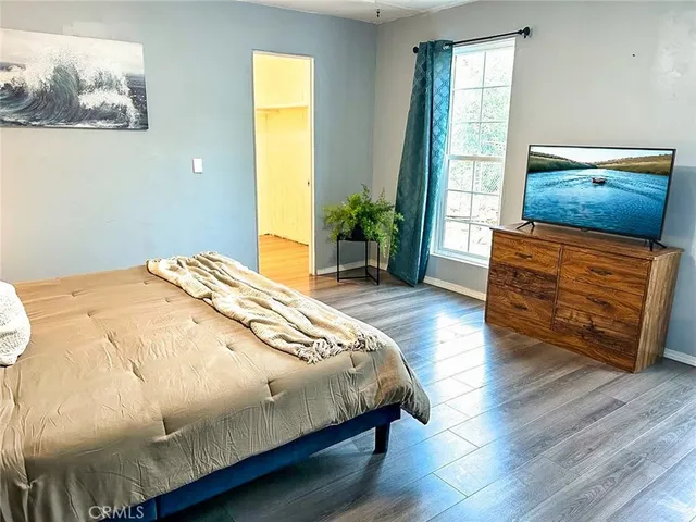 a bedroom with bed and wooden floor