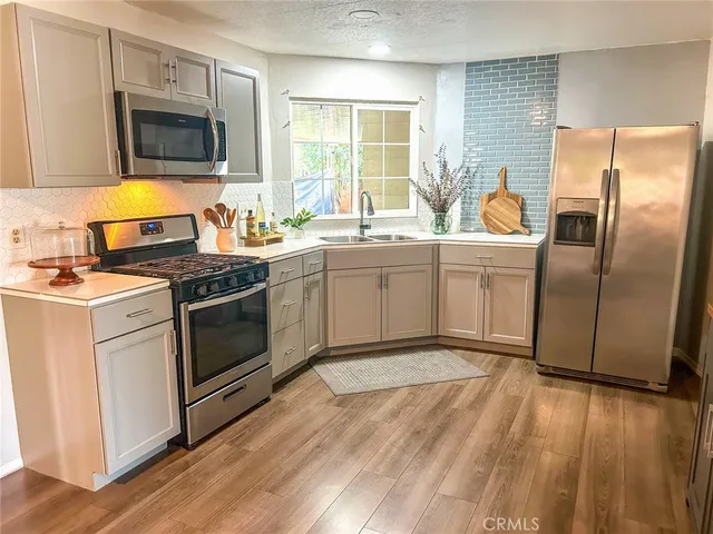 a kitchen with stainless steel appliances granite countertop a stove a sink and a refrigerator