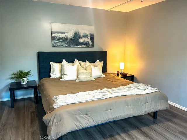 a bedroom with a bed and a painting on the wall