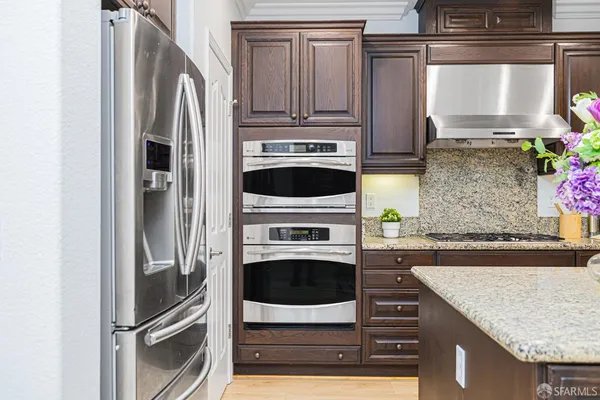 a kitchen with a dining table chairs and refrigerator