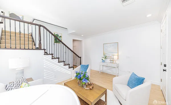 a living room with furniture and wooden floor