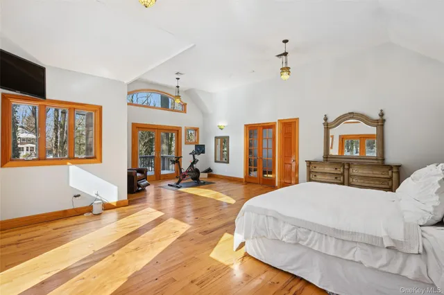 a bedroom with a bed a dresser next to a window