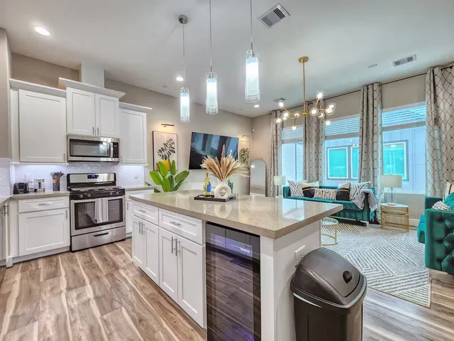 a kitchen with kitchen island granite countertop a sink stove and wooden cabinets