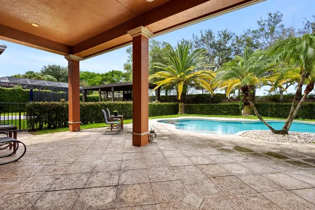 a view of swimming pool with outdoor seating and plants