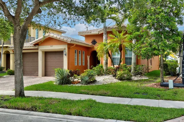 a front view of a house with a yard and potted plants