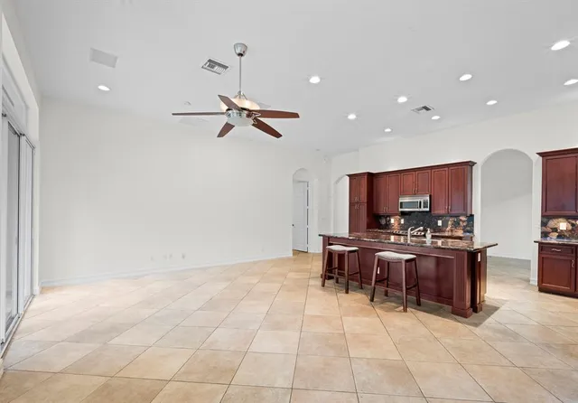 a living room with furniture a flat screen tv and kitchen view