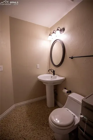 a bathroom with a toilet sink and mirror