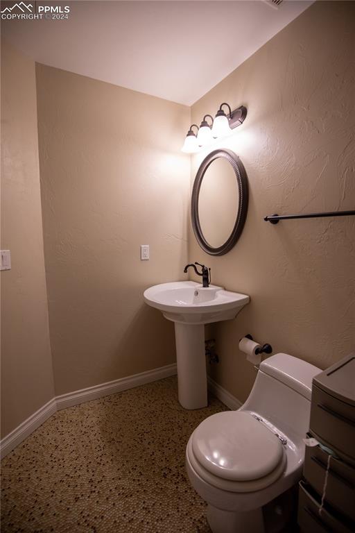 1510 York Road, Unit 103 Colorado Springs, CO 80918 - Photo 26 of 28 a bathroom with a toilet sink and mirror