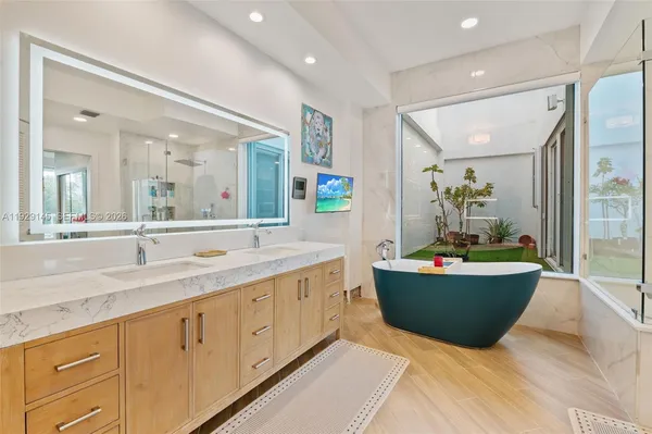 a spacious bathroom with double vanity a mirror and a sink