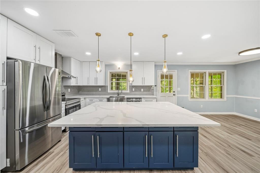 2702 Davenport Road Northwest Duluth, GA 30096 - Photo 11 of 48 a kitchen with stainless steel appliances kitchen island granite countertop a refrigerator a sink dishwasher and a wooden cabinets