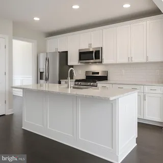 a kitchen with stainless steel appliances a sink a stove a microwave and cabinets