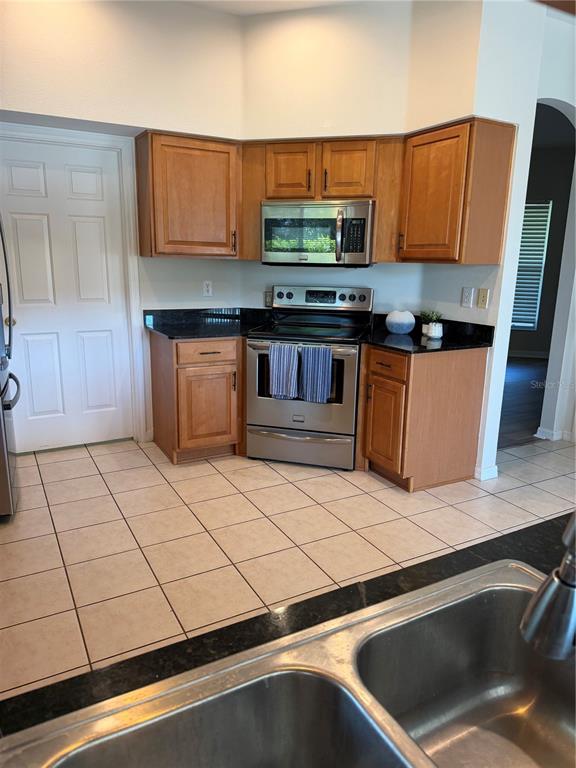 10760 Plantation Bay Drive Tampa, FL 33647 - Photo 15 of 39 a kitchen with stainless steel appliances kitchen island granite countertop a sink a stove counter space and cabinets
