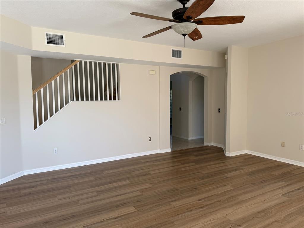 10760 Plantation Bay Drive Tampa, FL 33647 - Photo 6 of 39 a view of an empty room with wooden floor and a ceiling fan