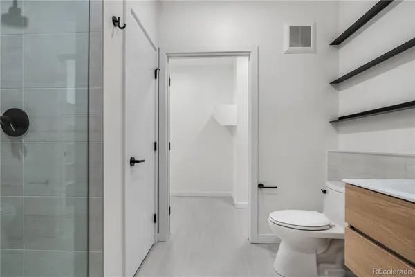 a bathroom with a toilet a sink and shower